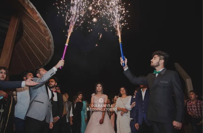 Friends holding up cold-fire sparklers for the couple's grand entrance